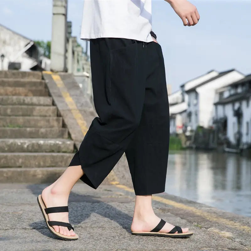 Les pantalons de plage décontractés en lin pour hommes sont des pantalons en coton noirs à coupe ample et fuselée, avec une coupe décontractée et des poches latérales, adaptés à un usage quotidien.