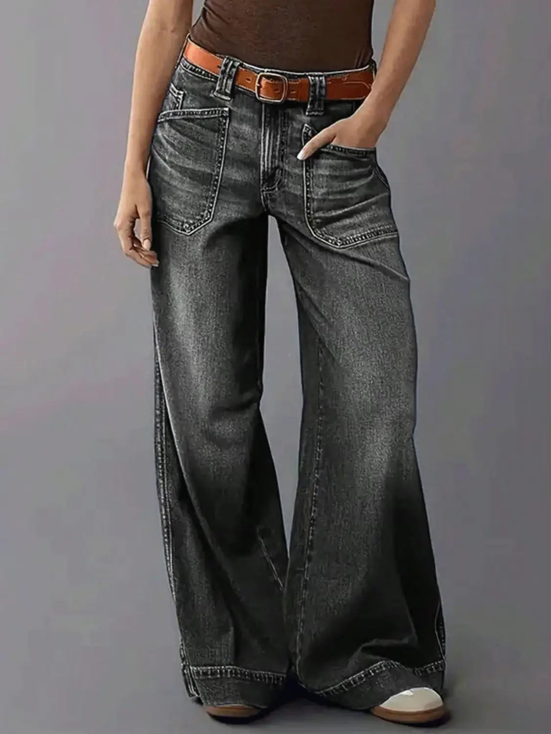Dark gray wide-leg denim pants with a brown leather belt showcasing a stylish casual outfit.