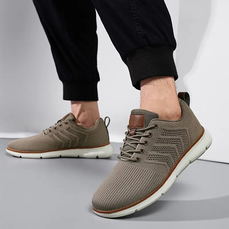 Beige knit mesh sneaker for men with brown leather accents and white rubber sole designed for casual flying woven shoes.