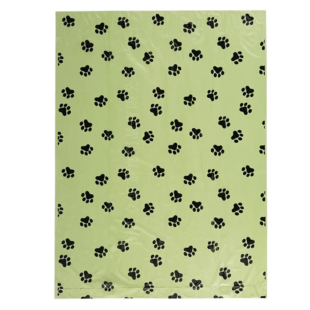 Light green biodegradable dog waste bag with black paw print pattern designed as thickened pet poop bags for convenient disposal.
