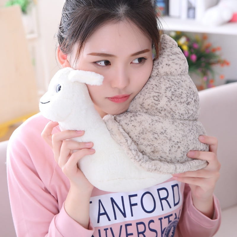 white plush snail-shaped pillow with a speckled gray shell and embroidered facial features soft stuffed animal shell doll