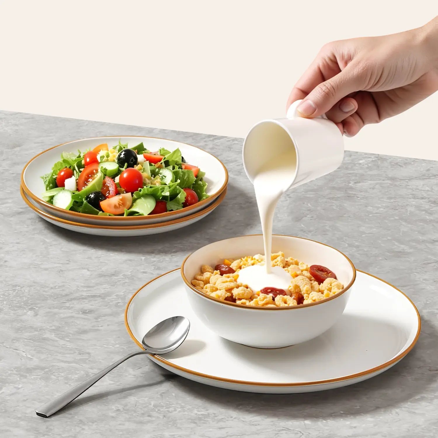 white ceramic pitcher with a gold rim pouring milk into a bowl of cereal from a white ceramic dinnerware set gold rim 12 piece