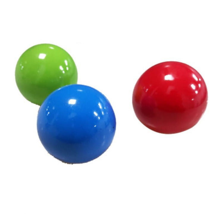 Three glossy spherical sticky wall ball stress relief glow squash toys in vibrant green blue and red.