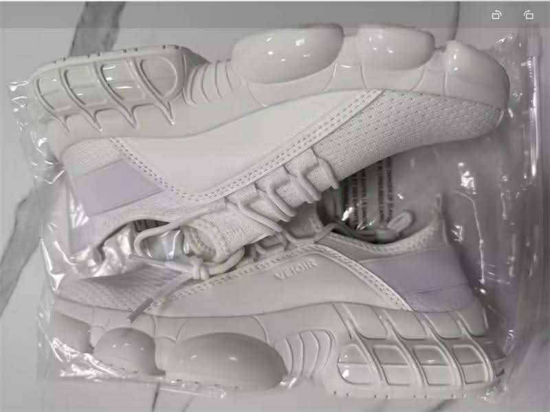 Weiße klobige Mesh-Laufsneaker mit einer glänzenden, geformten Sohle und einem leichten, atmungsaktiven Obermaterial.