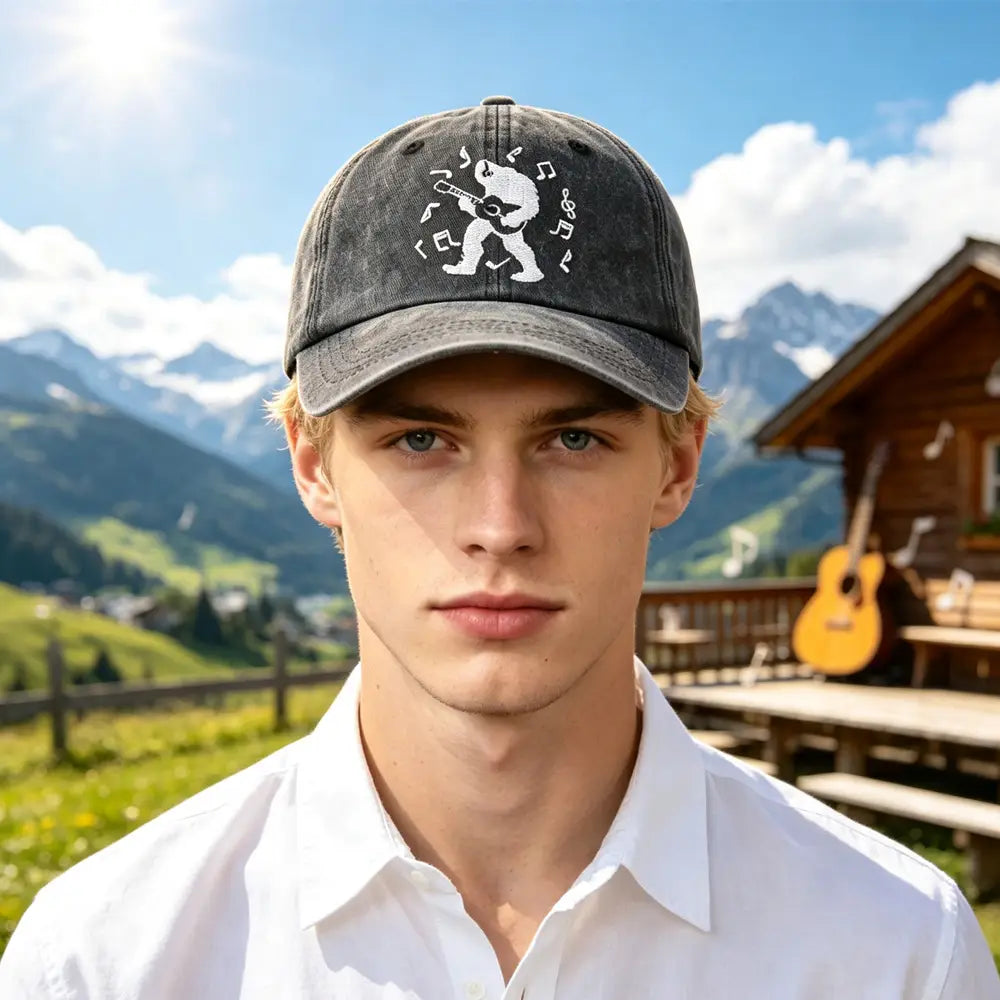 Dark gray distressed baseball cap featuring a white embroidered design of a bear playing guitar surrounded by musical notes called Bigfoot Guitar Baseball Cap Vintage Distressed Hat.