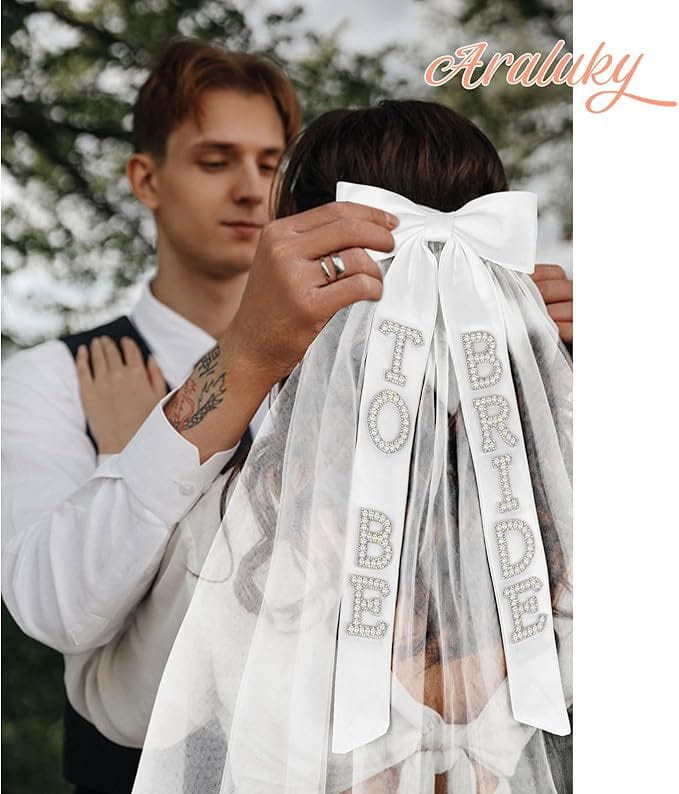White sheer bridal bow veil with rhinestone-embellished to be bride sash displayed from the back side.