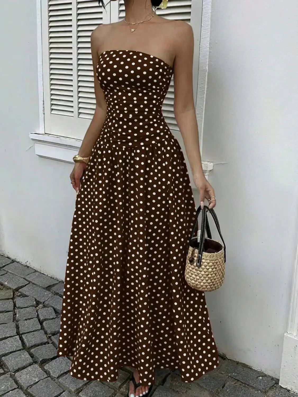 Brown strapless maxi dress with white polka dots featuring an off shoulder design suitable for elegant occasions.