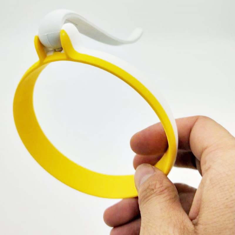 Gelber und weißer Silikon-Eierring für eine runde Omelettform mit Griff, mit gebogenem Hakenaufsatz.