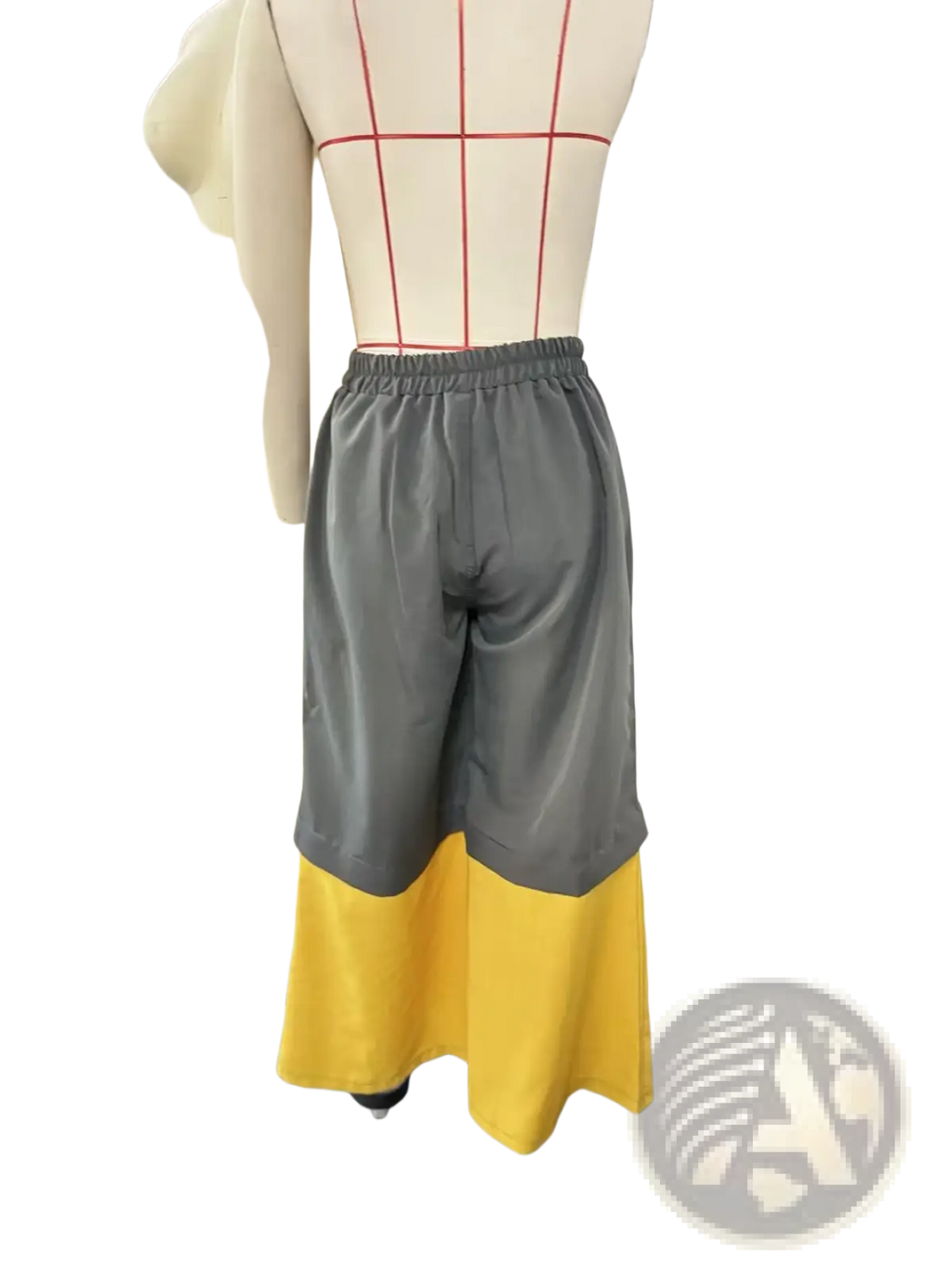 Deconstructed denim wide leg pants in gray and yellow two-tone with elastic waistband displayed on mannequin