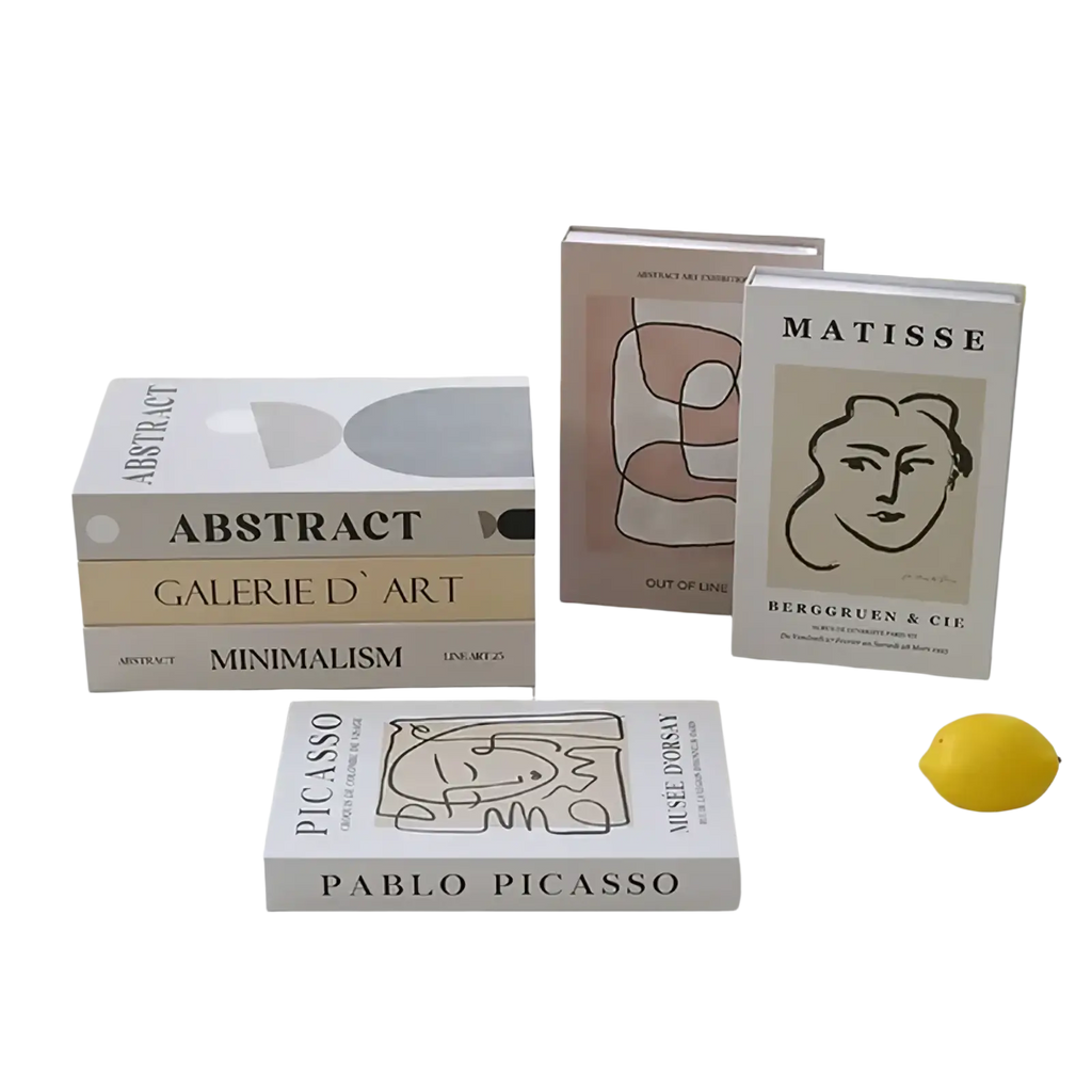White rectangular decorative fake book with black line art face and bold matisse text for coffee table decor