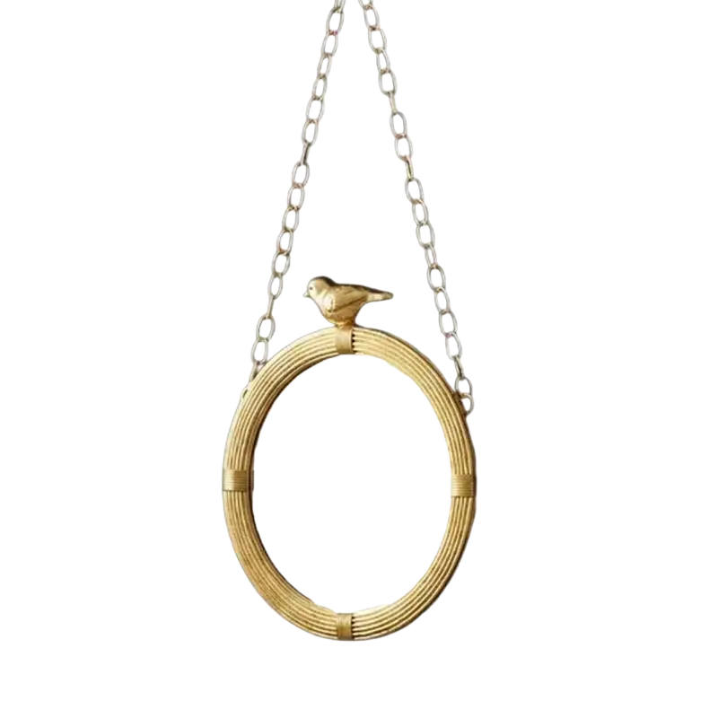 Gold-toned decorative mirrour with woven resin frame and bird figurine for interior wall hanging suspended by silver chain