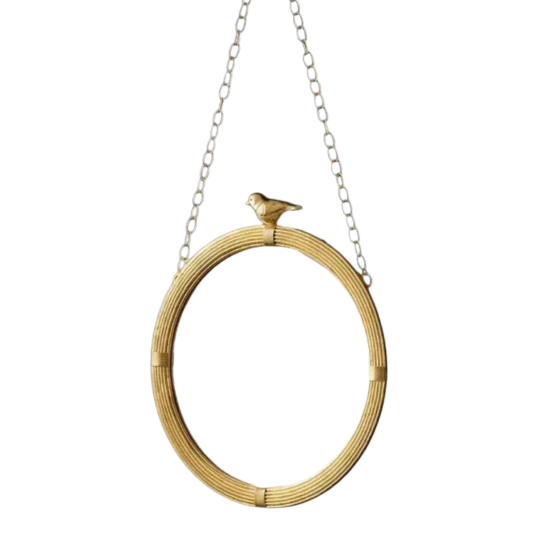 Gold-toned decorative mirrour with woven rattan resin frame and bird figurine for interior wall hanging suspended by silver chain