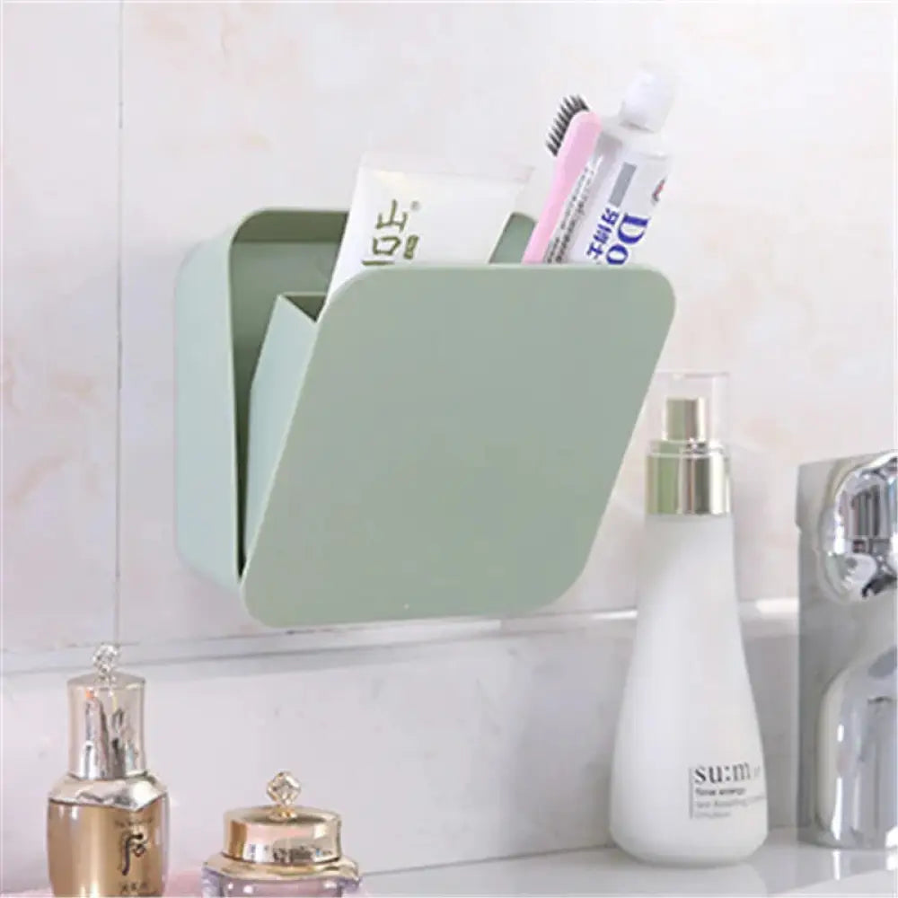 A sleek mint green wall mounted toothbrush holder with minimalist design and smooth plastic finish for vanity organization