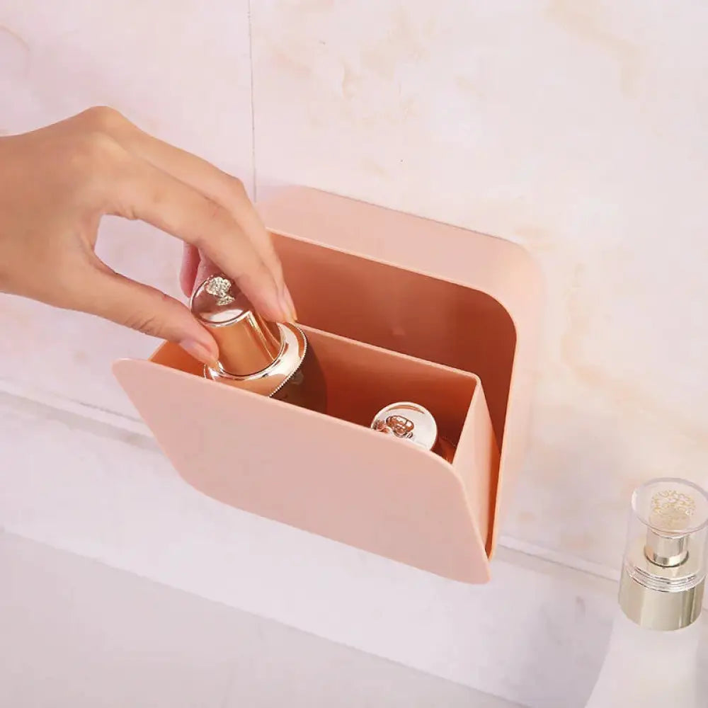 Blush pink wall-mounted vanity organizer with hinged lid and smooth matte finish for makeup storage
