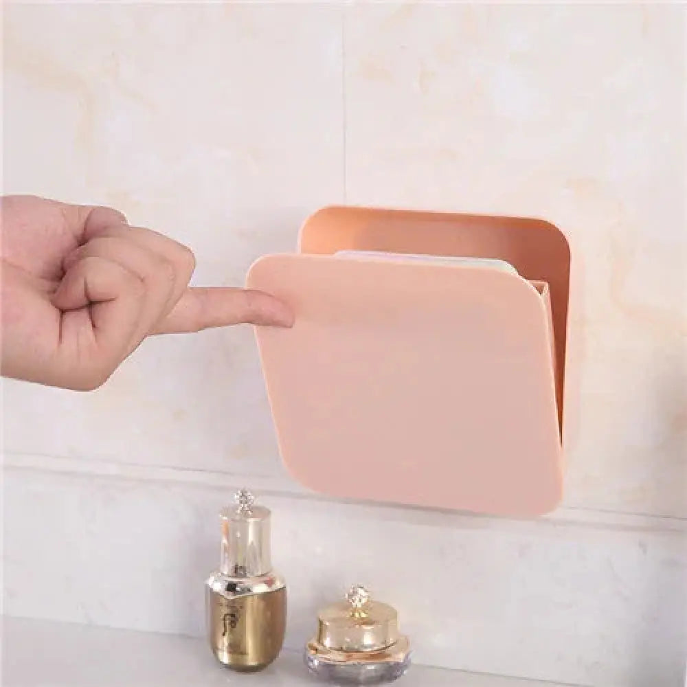 A soft peach pastel wall mounted vanity organizer made of smooth plastic with a hinged lid for makeup storage