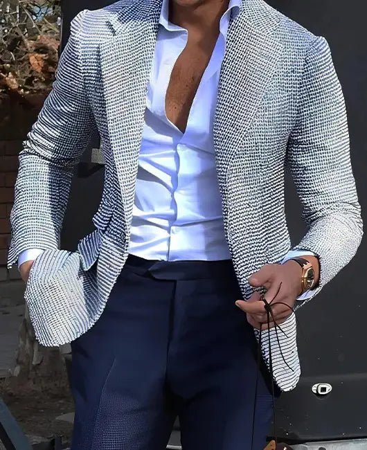 Ein stilvoller Herren-Karos-Blazer Slim Fit in einem strukturierten grauen und weißen Karo-Muster, kombiniert mit dunkelblauen Hosen.
