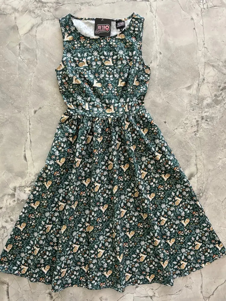 A sleeveless dark green cotton midi dress with floral and snail pattern, fitted waist, flared skirt, and pockets