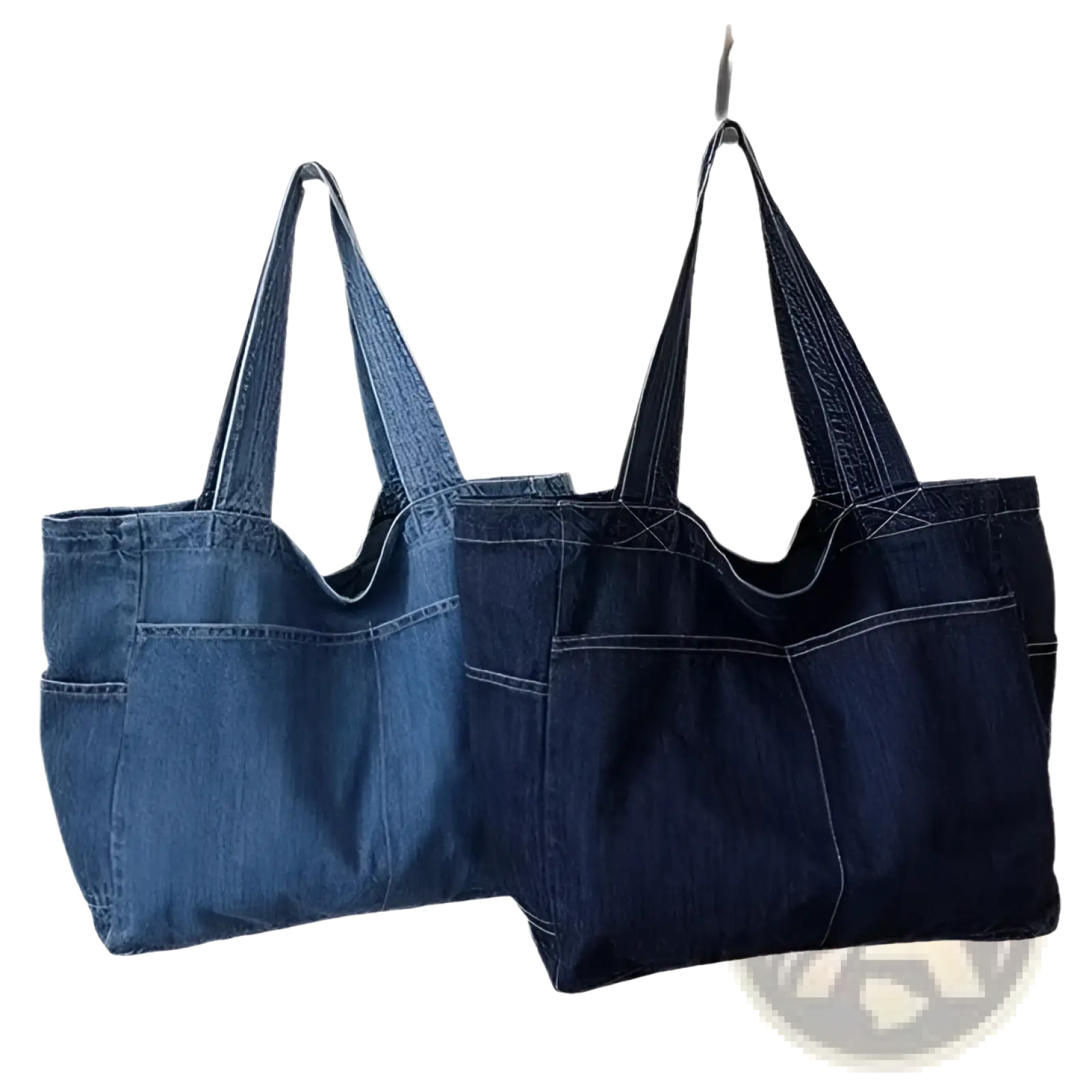 Two denim tote bags in medium blue and dark indigo with sturdy handles and visible stitching for large capacity use