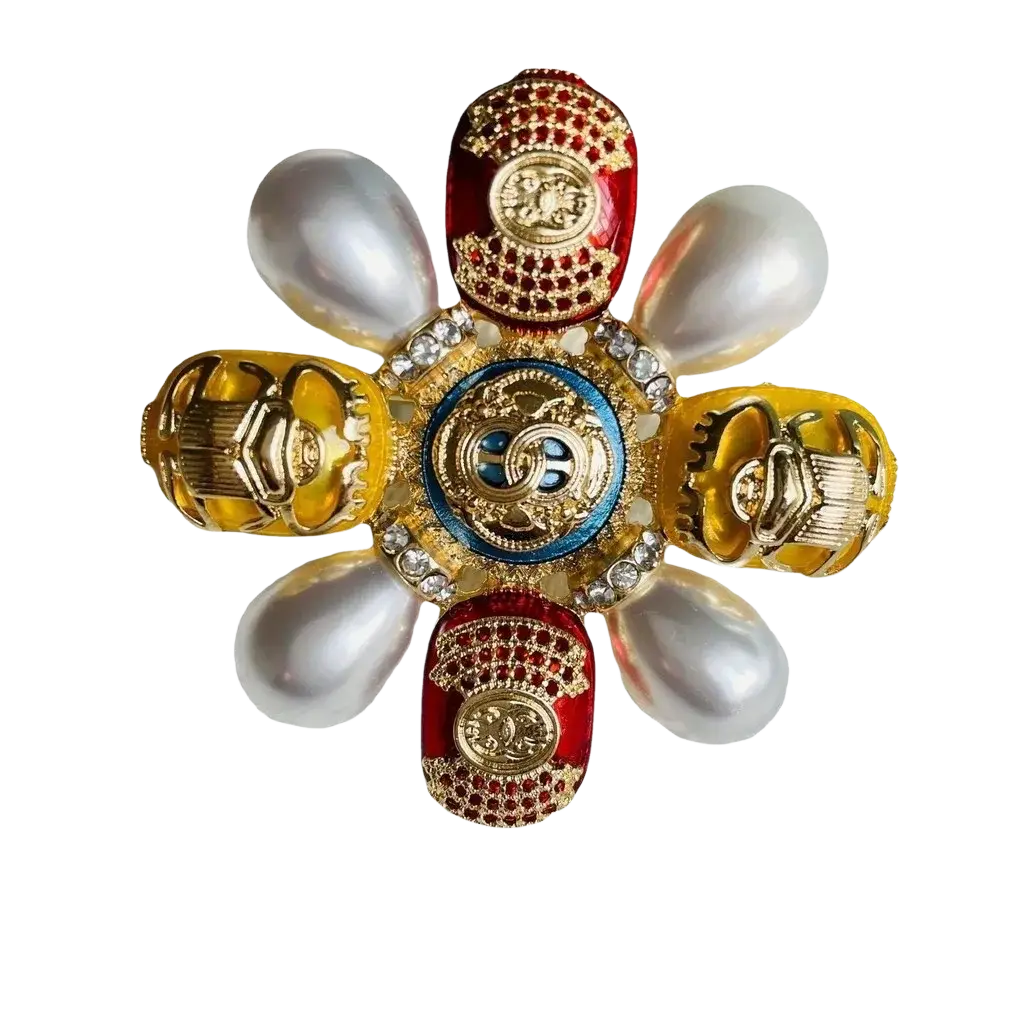 A luxurious Chanel designer pearl brooch with a blue enamel medallion and red yellow beetle rhinestone pin