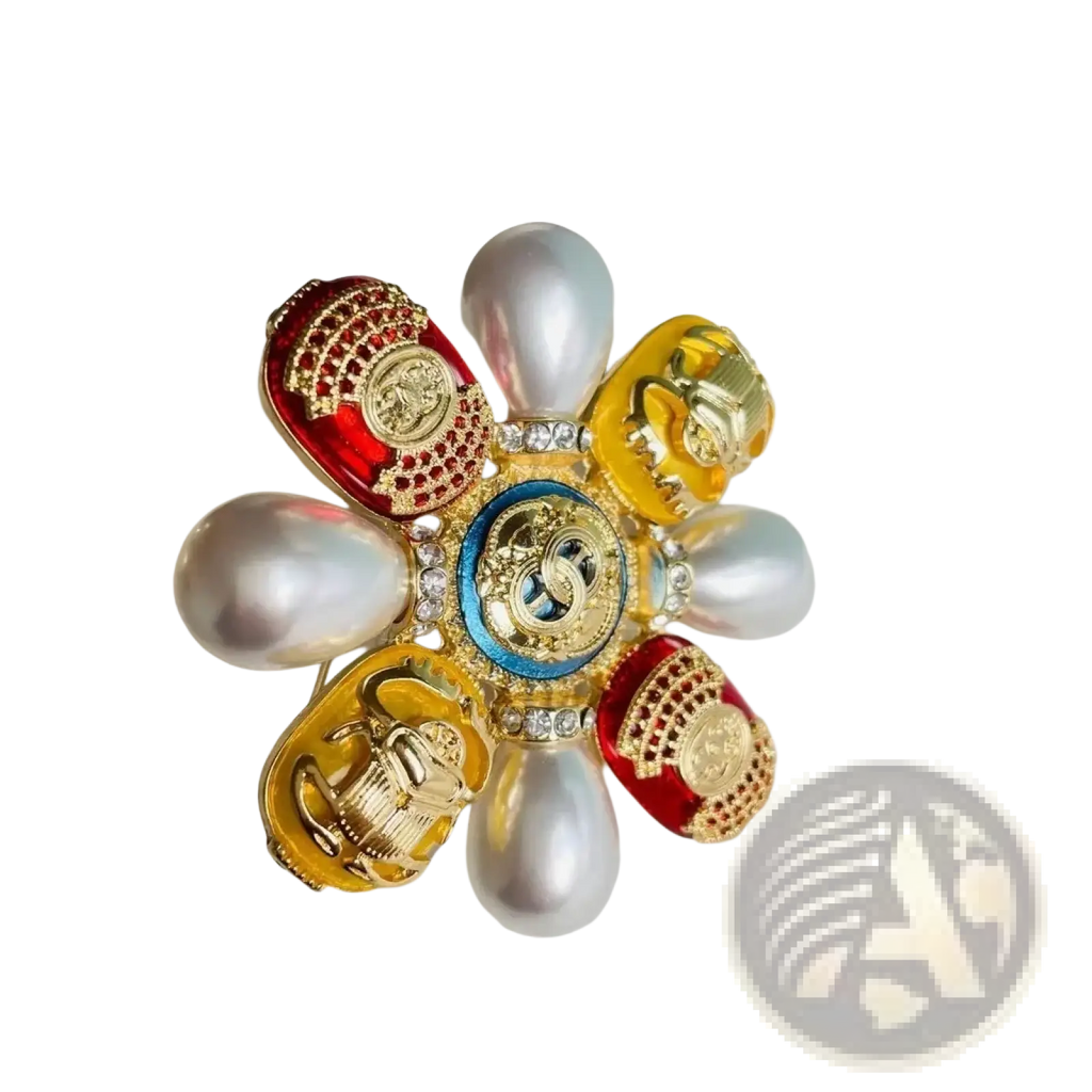 A vibrant flower-shaped Chanel brooch with red and gold enamel petals, pearls, crystals, and a central blue medallion