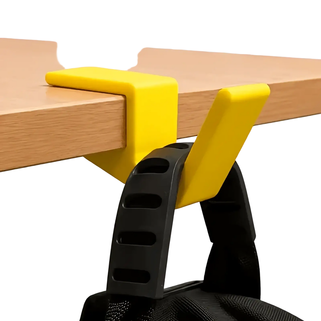 Bright yellow plastic desk-mounted backpack holder with black strap attachment for organizing bags on desk edge