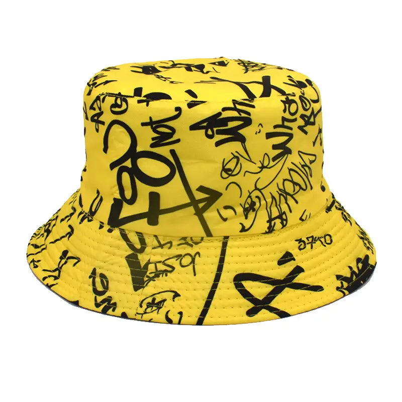 Chapeau bob jaune vif au style graffiti, avec un lettrage et des symboles noirs audacieux, conçu comme un chapeau de voyage respirant avec protection solaire.