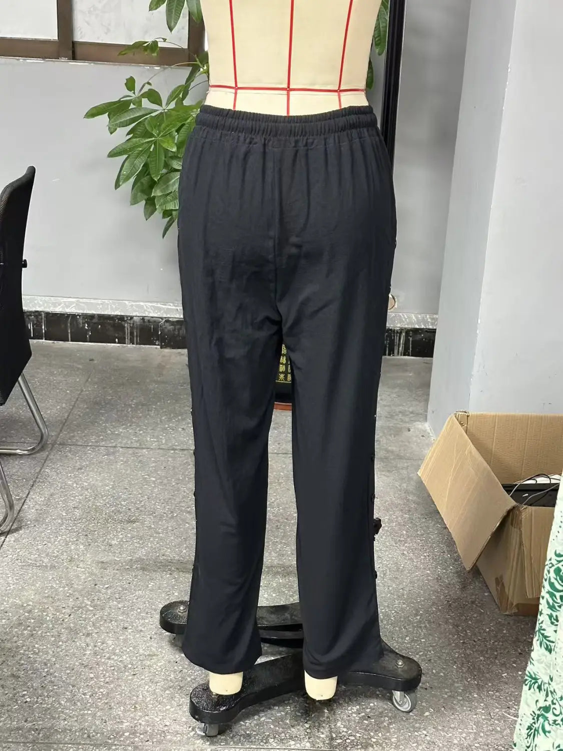 black straight-leg cropped patchwork button casual pants for women with an elastic waistband displayed on a mannequin