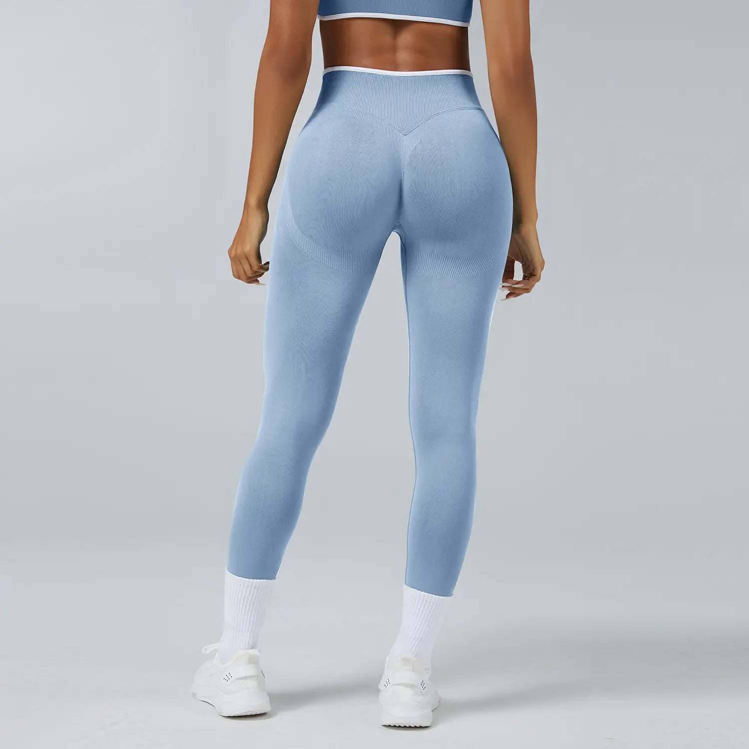 Nahtlose Sport-Yoga-Leggings mit hoher Taille in Hellblau mit gerippter Struktur und weißem Zierbesatz am Bund.