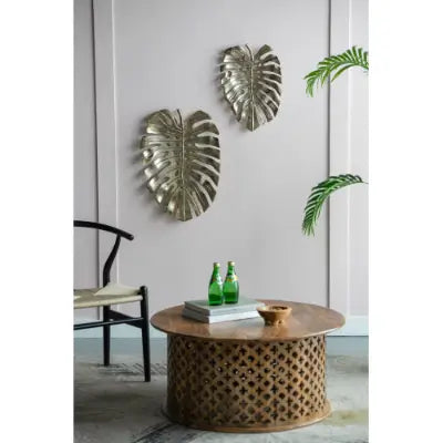 Two metallic leaf-shaped wall art pieces with textured surface and silver finish for gold monstera leaf wall decor and serving tray.