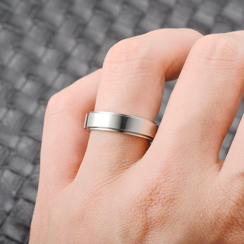 a sleek silver-toned stainless steel celestial anxiety spinner ring featuring two parallel grooves along its band in a modern design