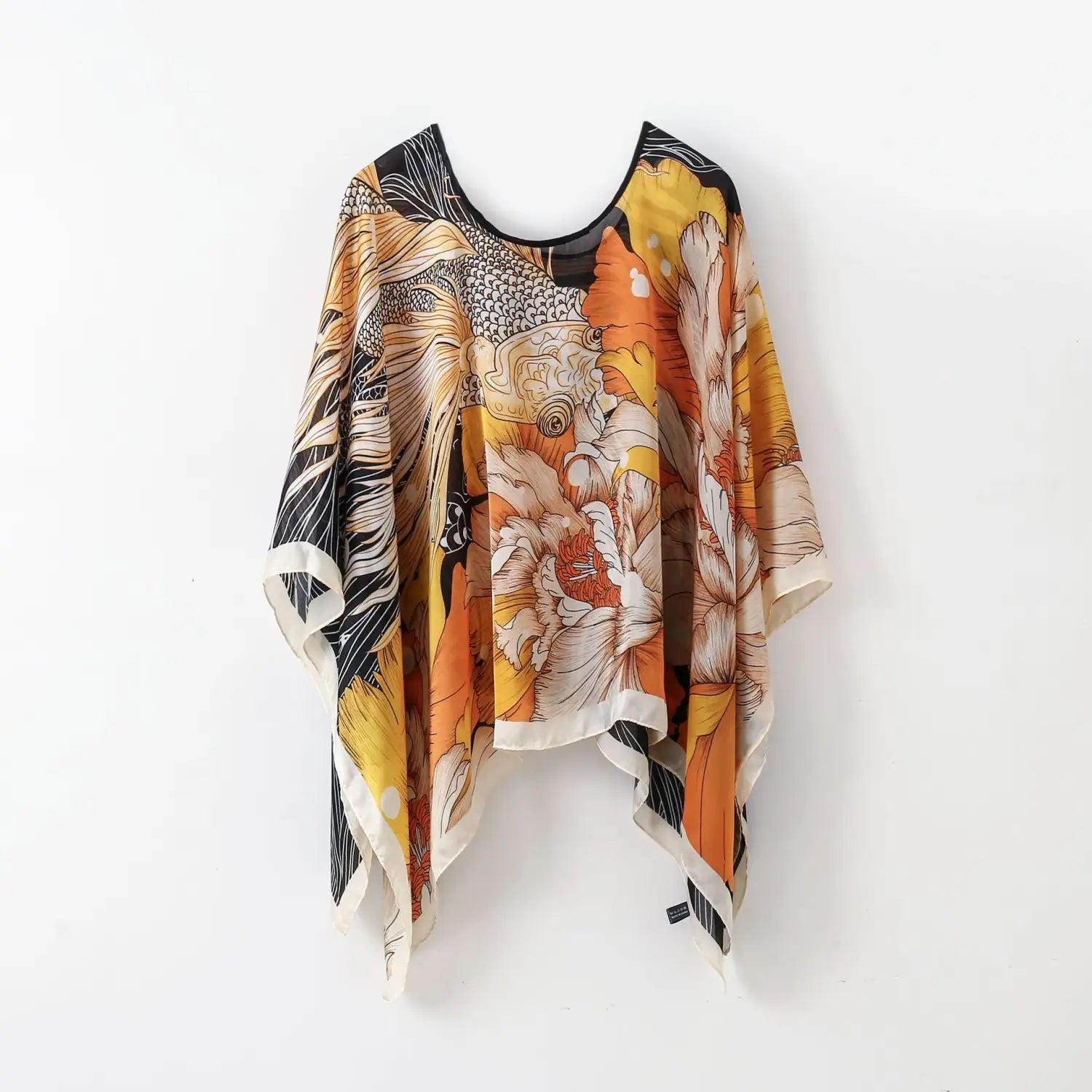 A flowing, loose-fitting printed silk patterned pullover shawl cape outerwear featuring a vibrant orange and black floral pattern with intricate white detailing.