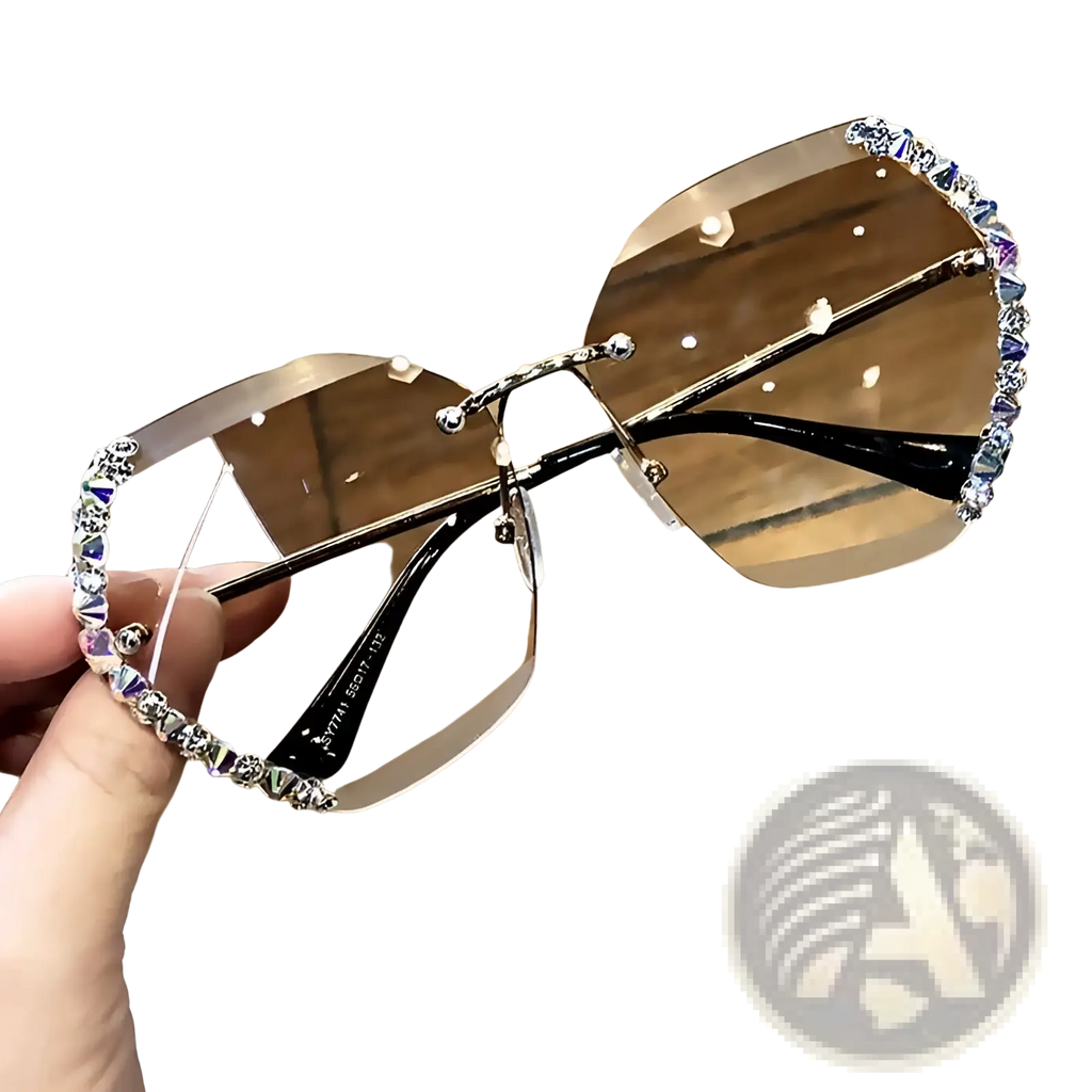 A pair of diamond studded rimless polygonal sunglasses with brown gradient lenses and black metal rhinestone bridge