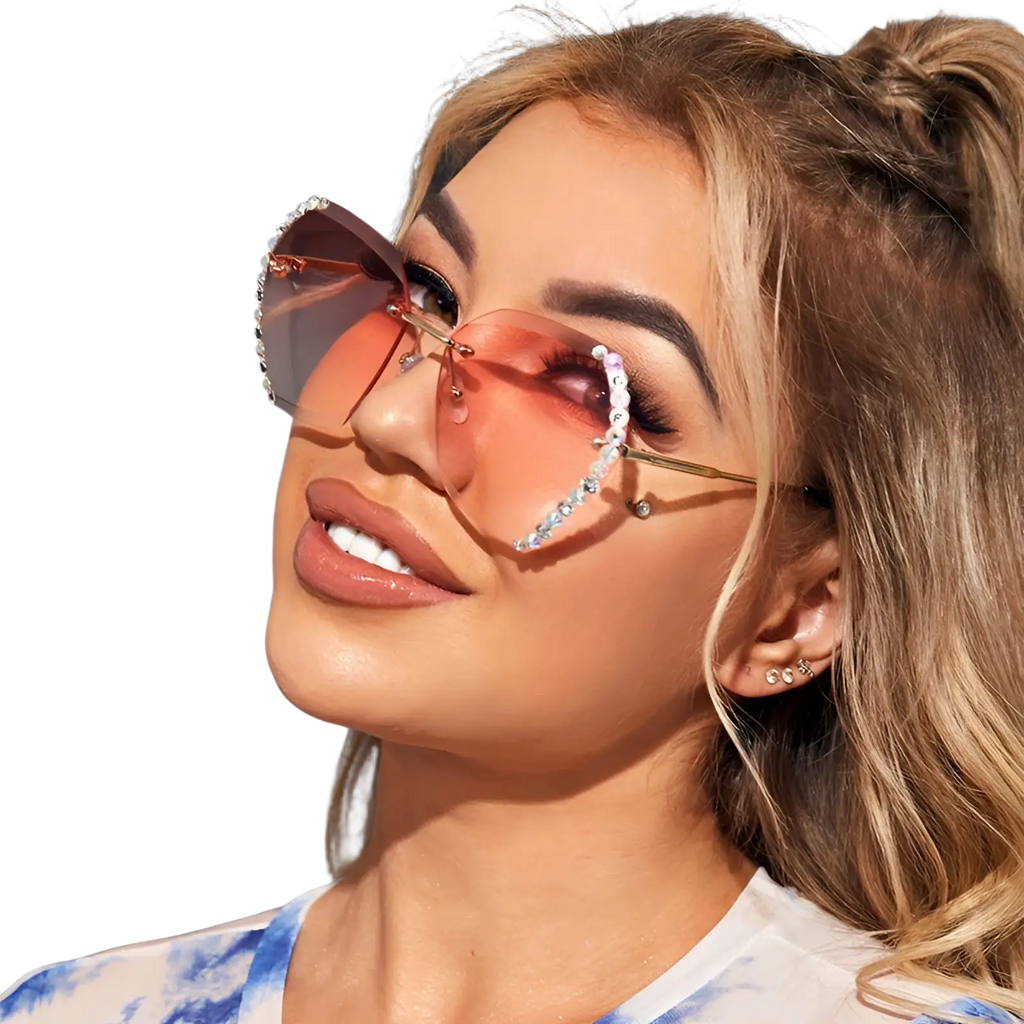 Pink gradient heart-shaped sunglasses with gold frames and diamond studded rhinestone detailing in a polygonal design