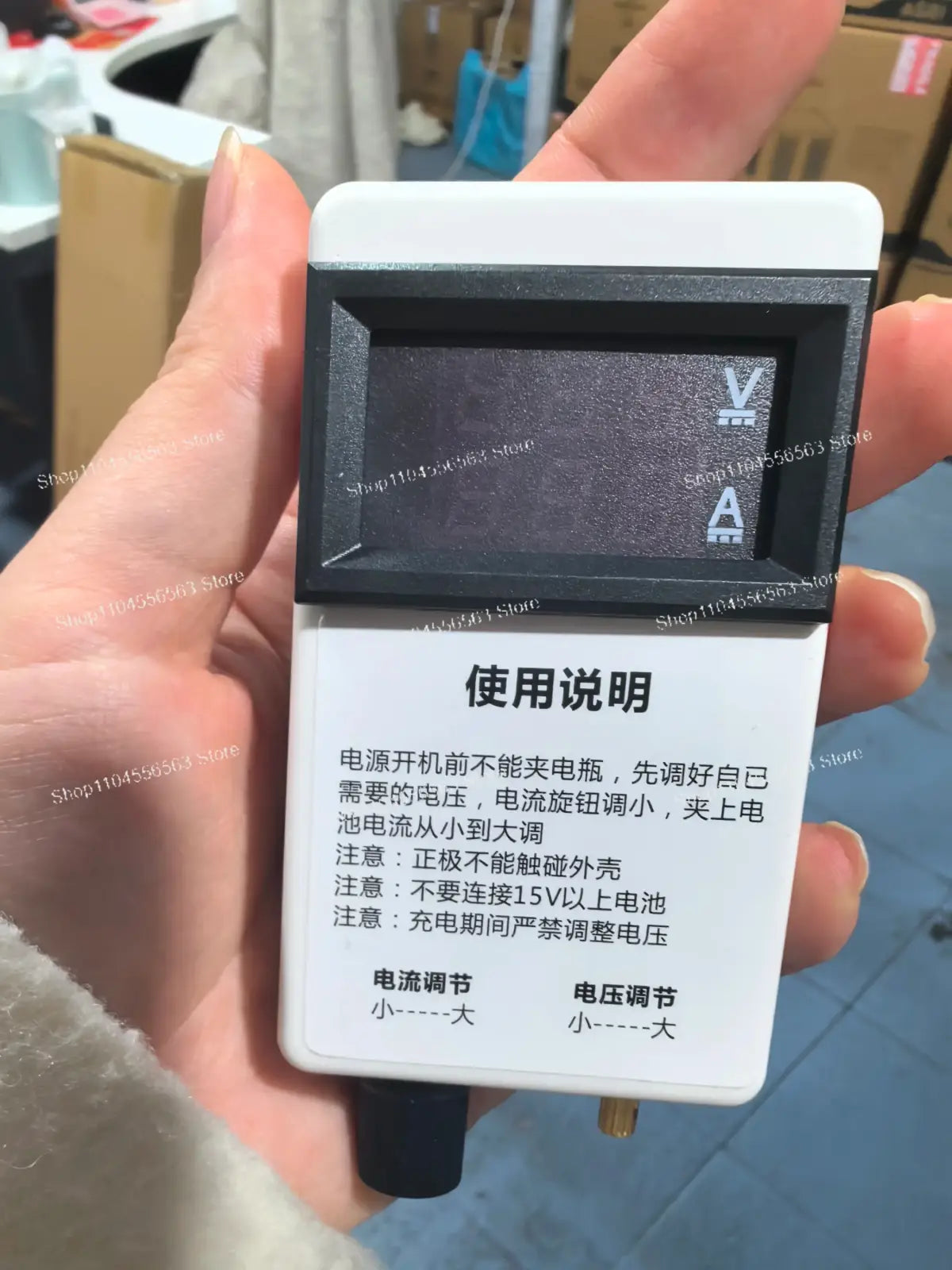 White and black digital voltage current regulator multimeter with rectangular display and chinese usage instructions on panel
