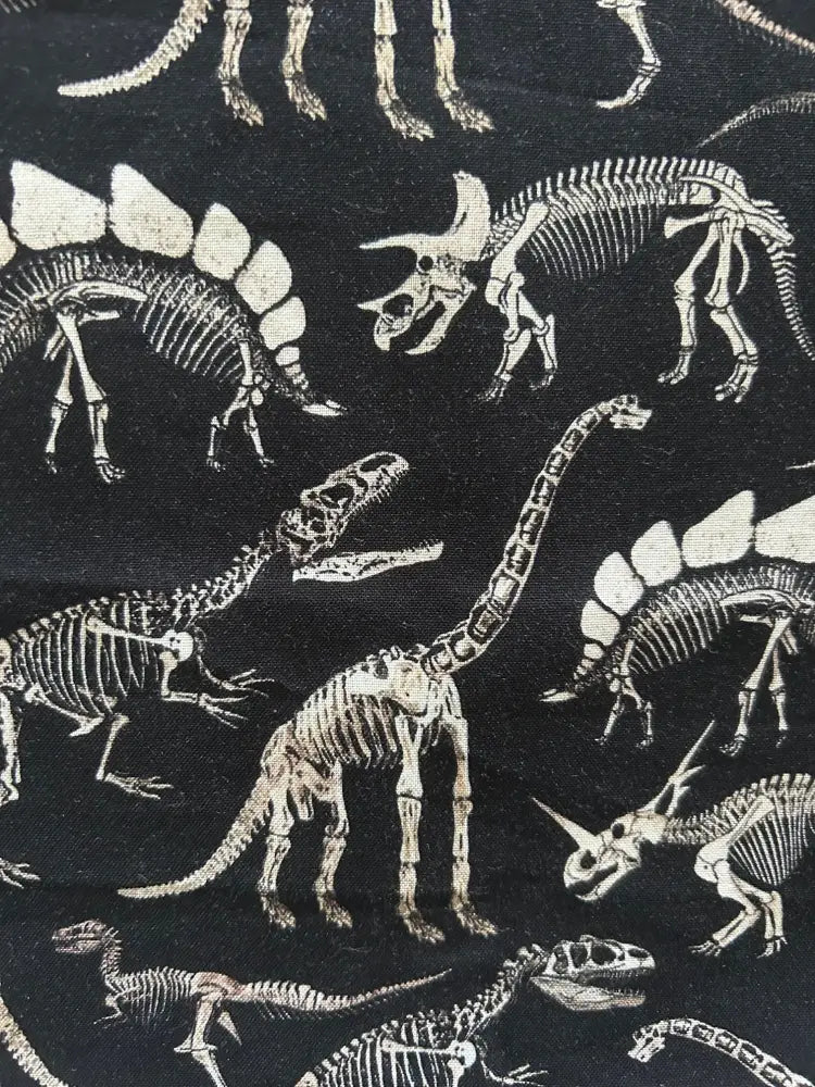 Black cotton sleeveless blouse with dino bones retro bow neck pattern of white dinosaur skeletons on fabric