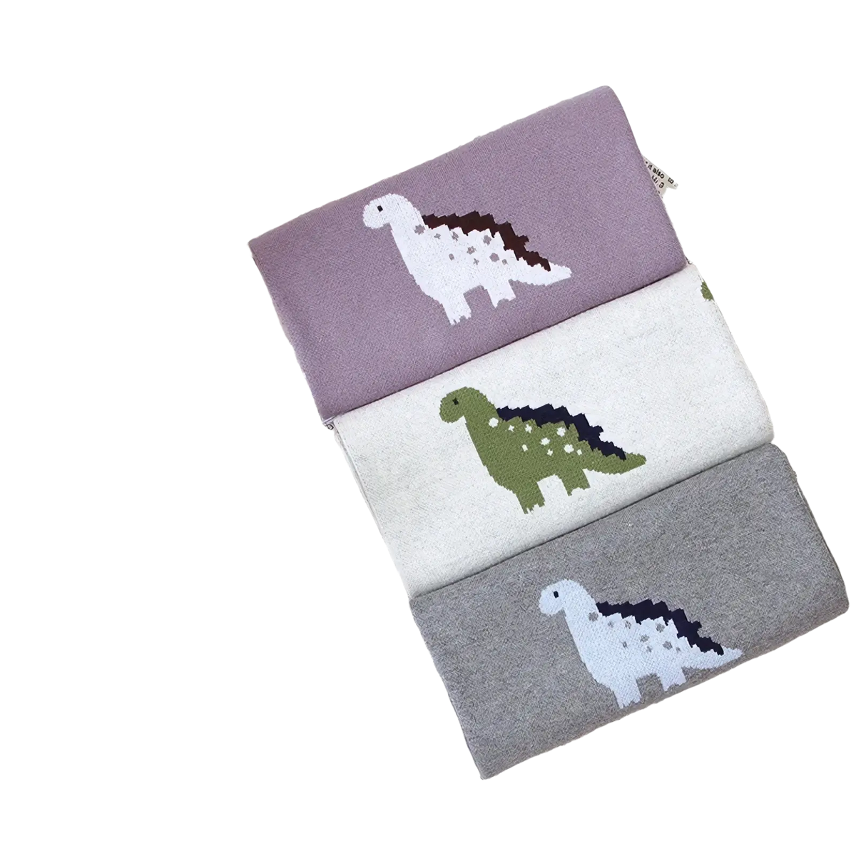 Three pairs of soft knitted cotton children’s socks in muted purple off-white and gray with dinosaur designs