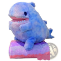 A plush blue shark with a pink mouth and white teeth sitting on a gradient purple and pink cushion 60cm doll