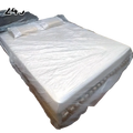 White plastic disposable waterproof mattress protector with clear slightly wrinkled surface and reinforced edges