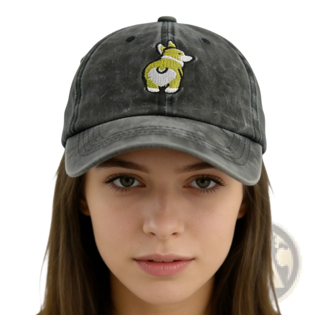 A faded gray distressed denim baseball cap featuring an embroidered corgi with green and white details on the front