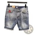 Distressed blue denim shorts with rolled cuffs and a red maple leaf patch on the front pocket