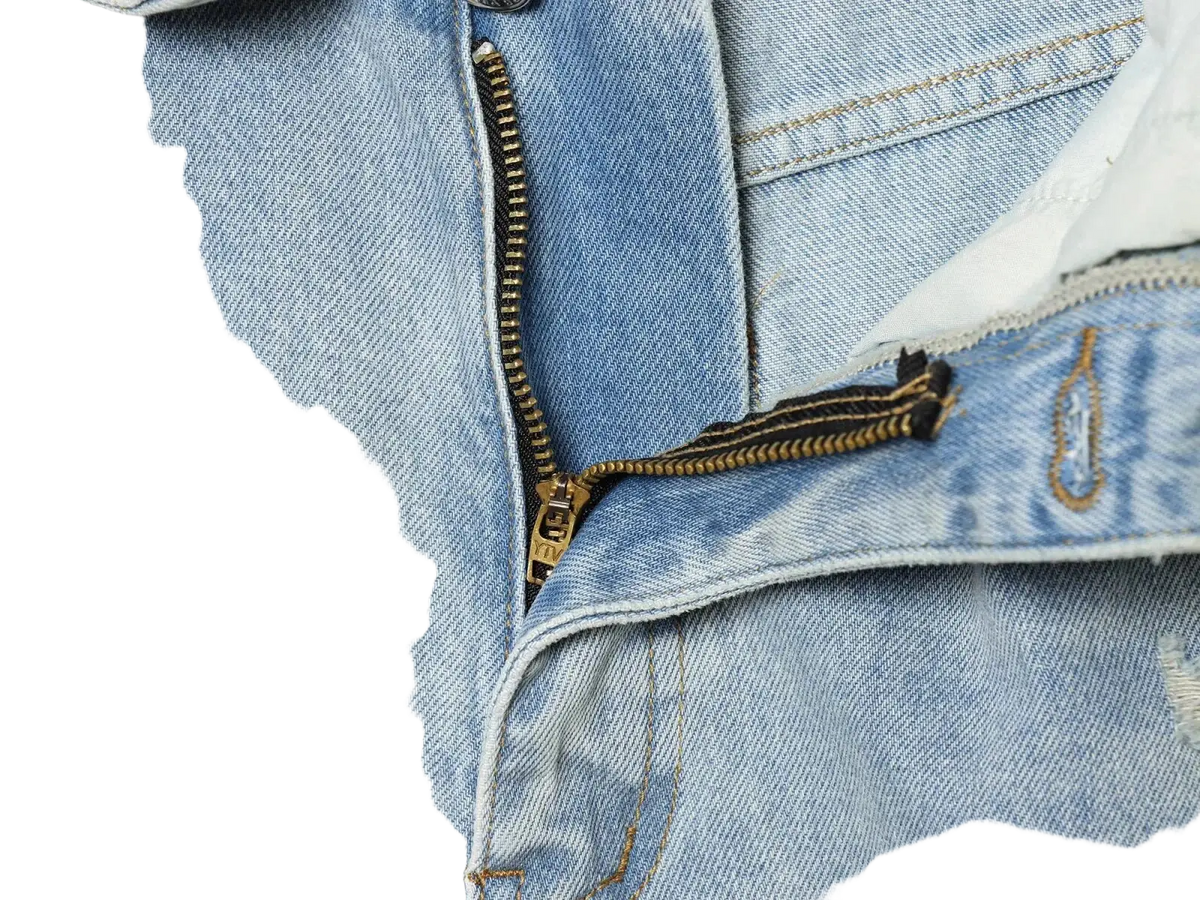 Distressed mid waist wide leg light-wash denim jeans with gold-toned zipper visible stitching and frayed edges