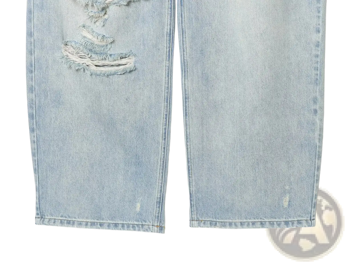 Light-wash distressed mid waist wide leg denim jeans with a frayed tear on the thigh in soft denim material