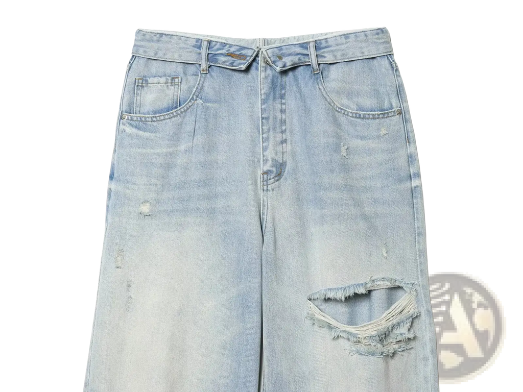 Distressed mid waist wide leg denim jeans in light wash with frayed holes and subtle fading on cotton fabric