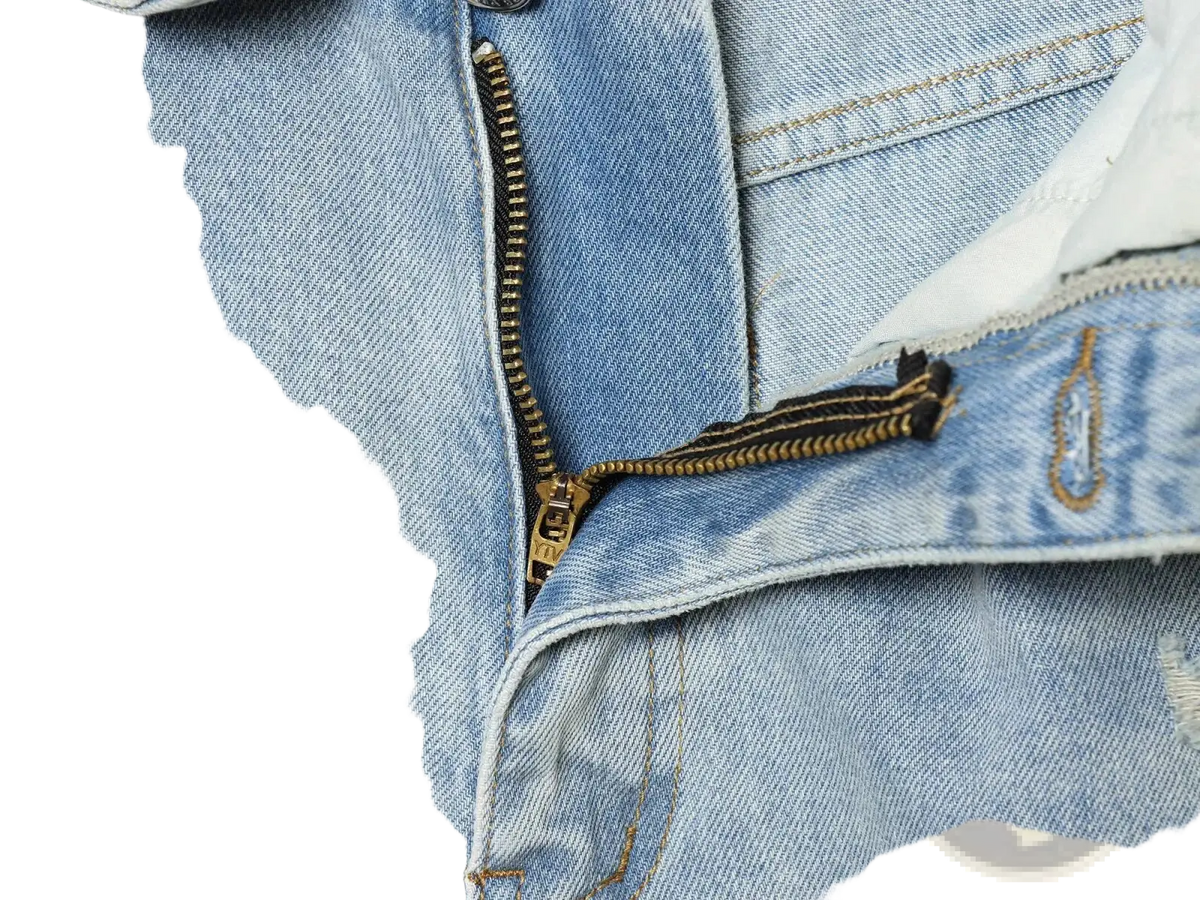 Distressed mid waist wide leg light-wash denim jeans with gold-toned zipper visible stitching and frayed edges