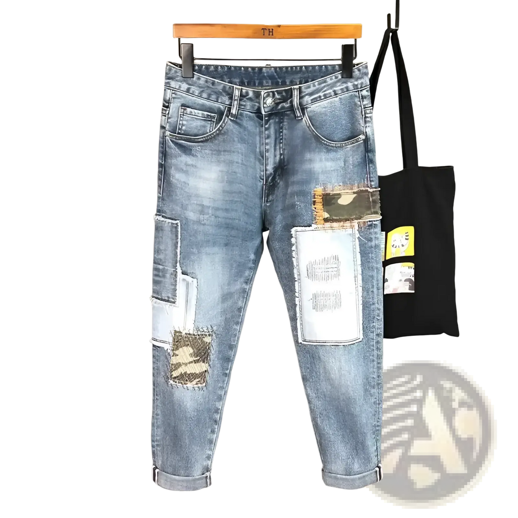 Distressed slim fit light wash denim jeans featuring distressed patches and camouflage fabric accents on the front
