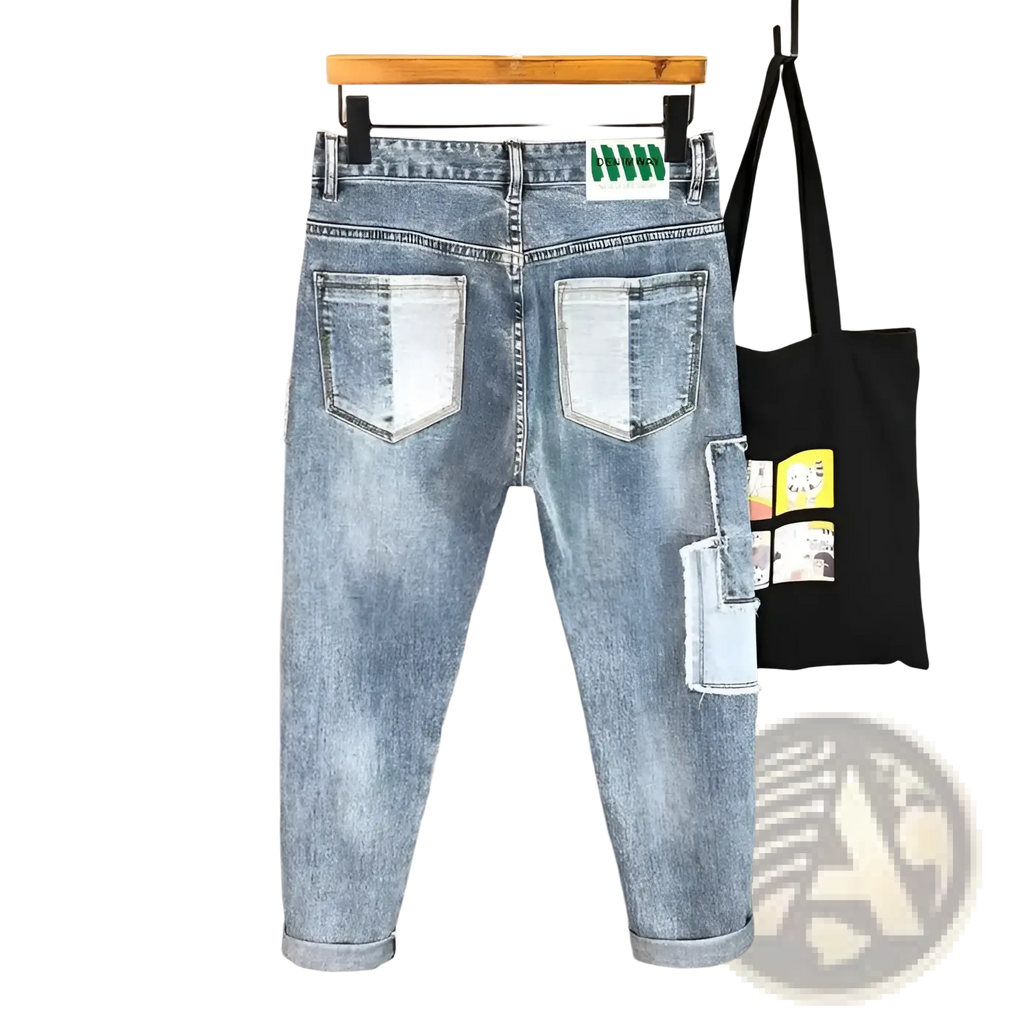 Back side of distressed slim fit light wash denim jeans with faded look and patchwork detailing on back pockets