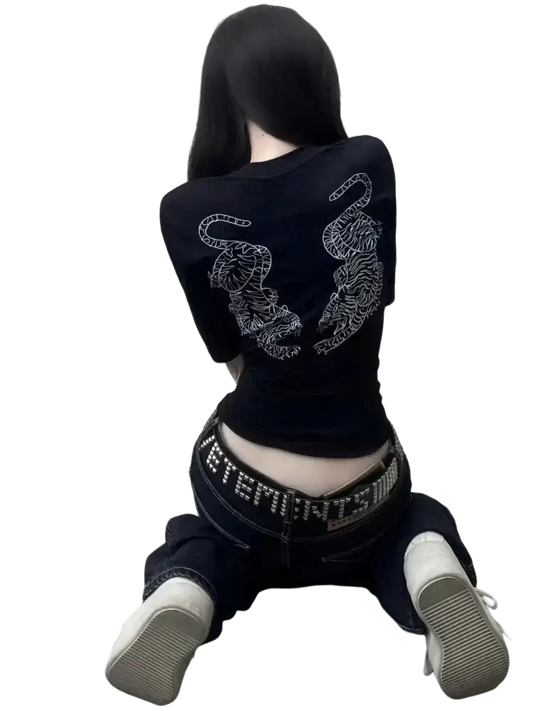 Black denim distressed slim flare jeans paired with a black crop top featuring intricate white tiger embroidery on the back