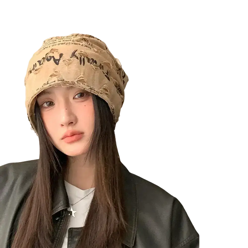 Beige distressed fabric streetwear beanie hat with black printed text and frayed edges for casual style