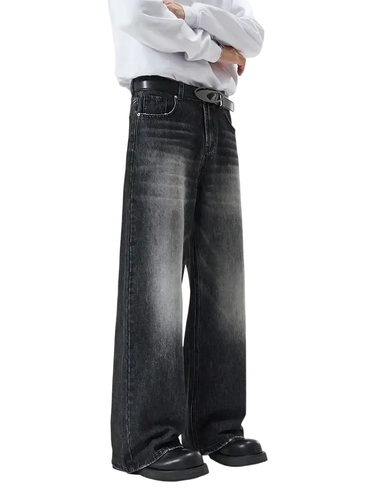 Distressed vintage baggy men denim jeans in black wide-leg denim with a faded, distressed wash and classic five pockets