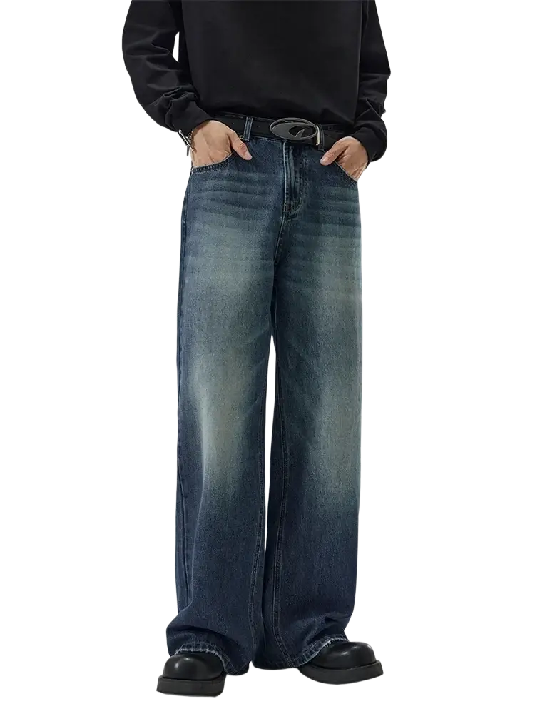 Distressed vintage baggy men denim jeans in faded blue wash with subtle whiskering and frayed hems